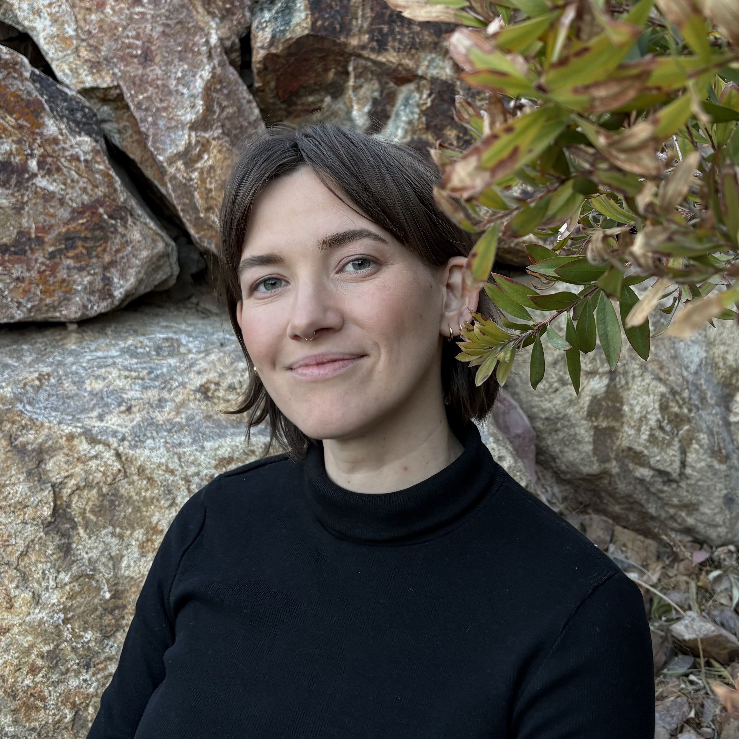 Taylor smiling in front of a rocky desert wall.