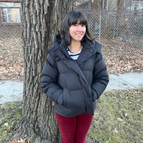 Emily standing by a tree at her home in Detroit